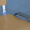 Stapelstuhl mit verchromtem Stahlrohrgestell und ergonomischer Buche-Sitzfläche Detailaufnahme